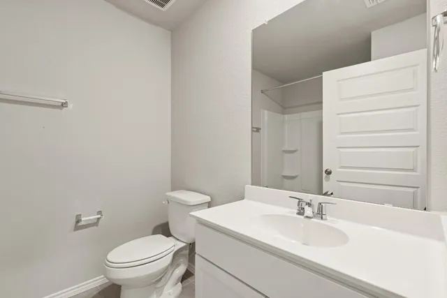 a bathroom with a granite countertop sink toilet and mirror