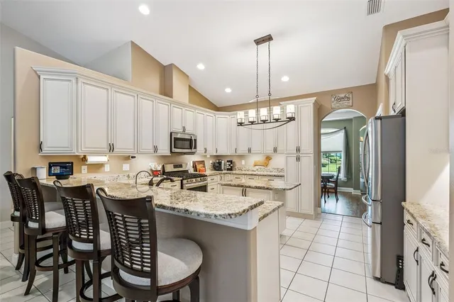 a kitchen with a dining table chairs sink and cabinets