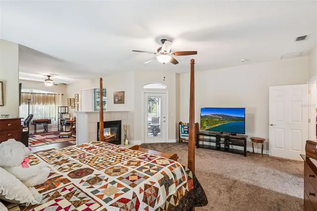 a spacious bedroom with a balcony a bed and a chandelier