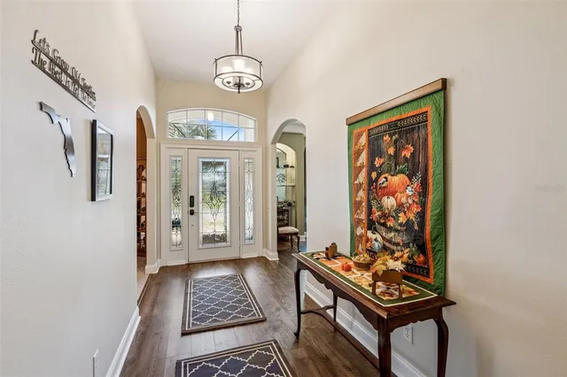 a view of a hallway with wooden floor and a chandelier