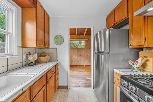 a kitchen with stainless steel appliances granite countertop a refrigerator a sink and a stove