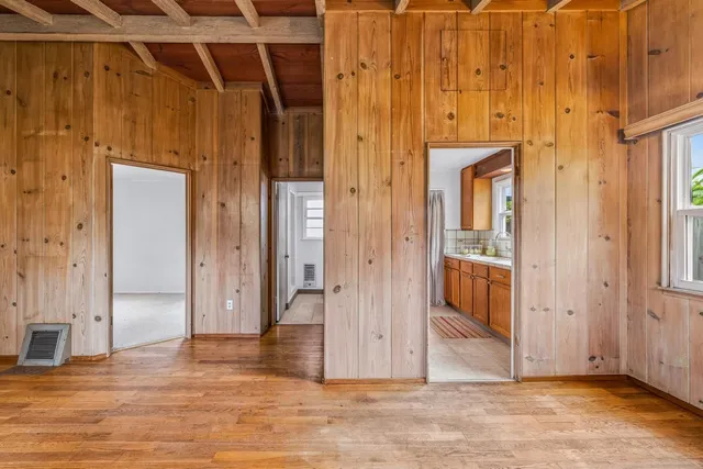 an empty room with wooden floor and entryway