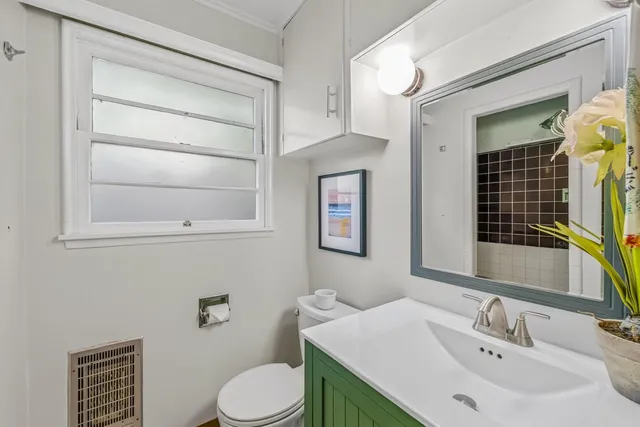 a bathroom with a sink vanity mirror and toilet