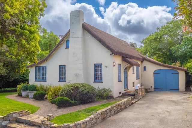 a front view of house with yard and trees around