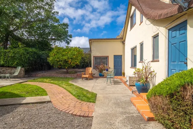 a view of a patio with chairs and potted plants