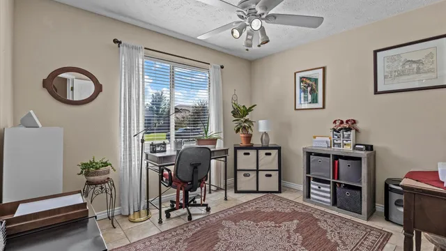 a view of a workspace with furniture and a window