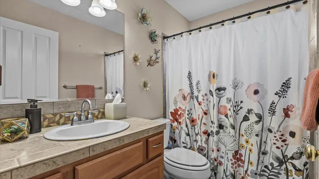 a bathroom with a granite countertop sink a toilet and a mirror