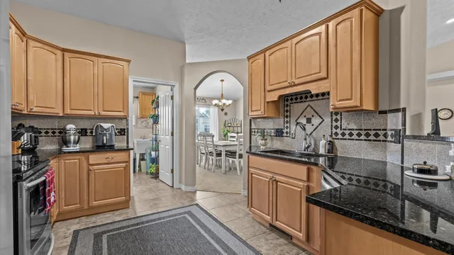 a kitchen with stainless steel appliances granite countertop a stove a sink and a refrigerator
