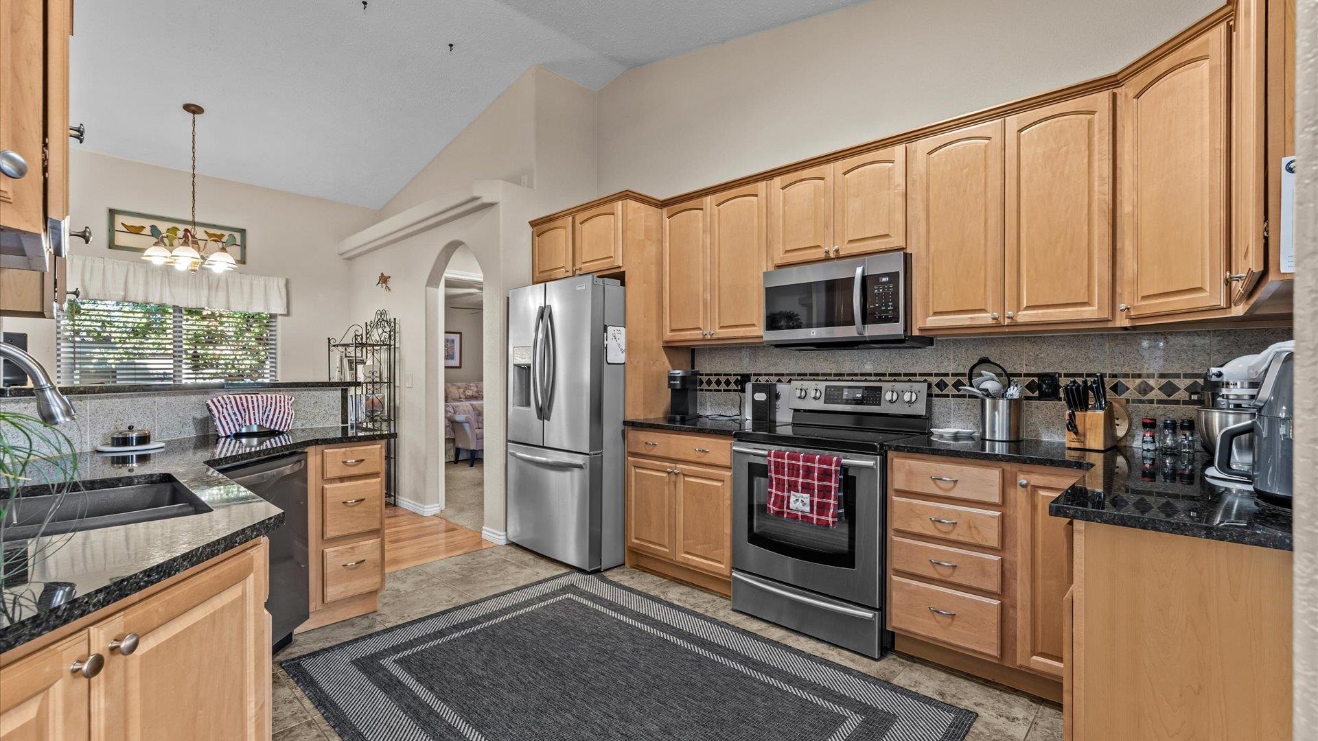 1355 Monument Court Fruita, CO 81521 - Photo 10 of 27 a kitchen with stainless steel appliances granite countertop a refrigerator stove and sink