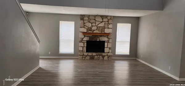 a view of a livingroom with wooden floor and a fireplace