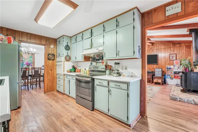 a kitchen with stainless steel appliances granite countertop lots of counter top space and wooden floor