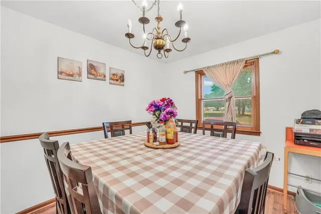 a living room with furniture a fireplace kitchen view and a flat screen tv