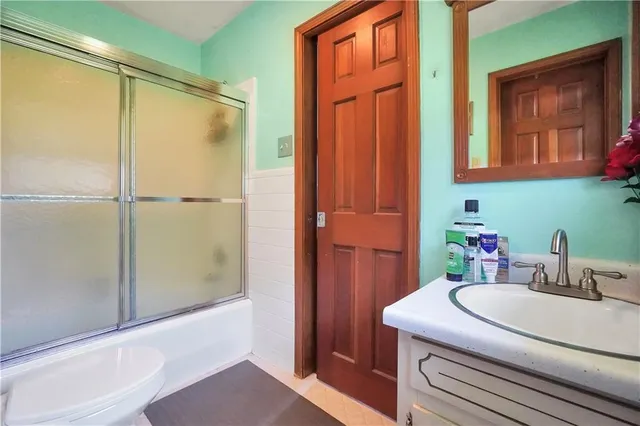 a bathroom with a granite countertop toilet sink and shower
