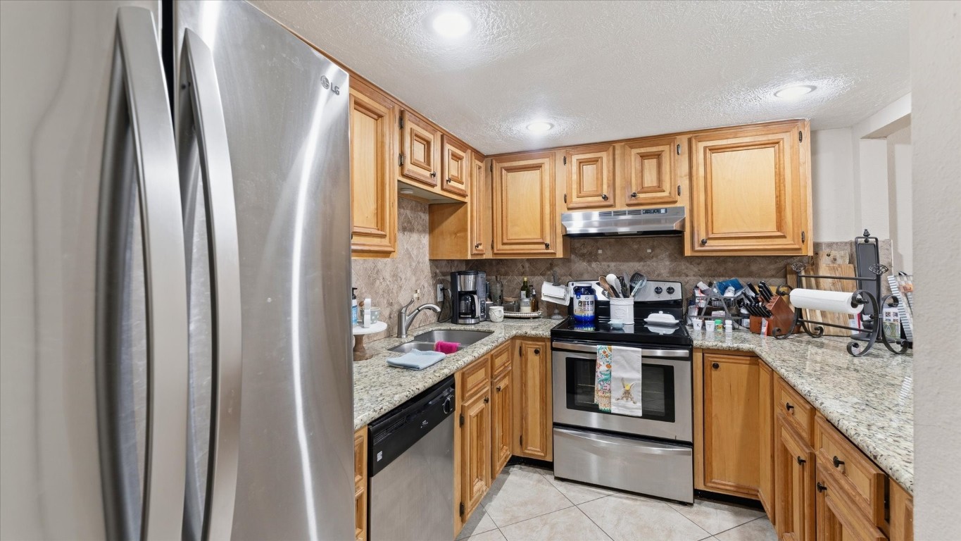 41 Regency Point Montgomery, TX 77356 - Photo 26 of 44 a kitchen with stainless steel appliances granite countertop a refrigerator and a sink