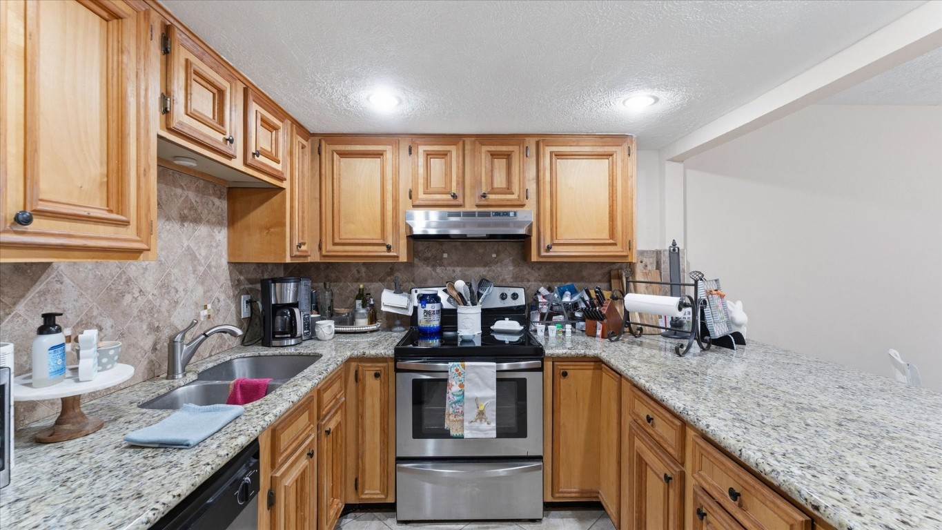 41 Regency Point Montgomery, TX 77356 - Photo 27 of 44 a kitchen with stainless steel appliances granite countertop a sink stove and cabinets