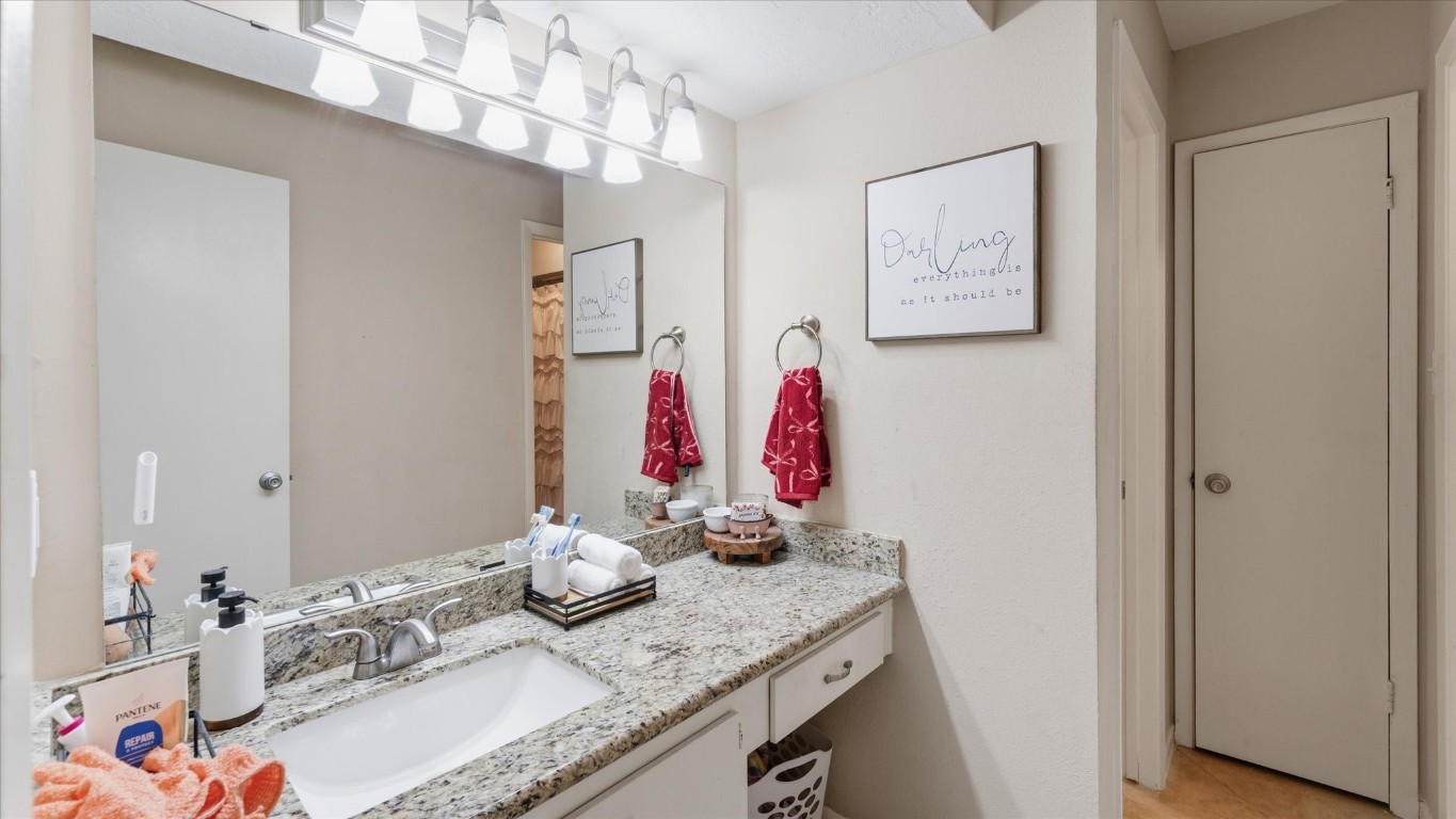 41 Regency Point Montgomery, TX 77356 - Photo 38 of 44 a bathroom with a granite countertop sink a mirror and shower curtain