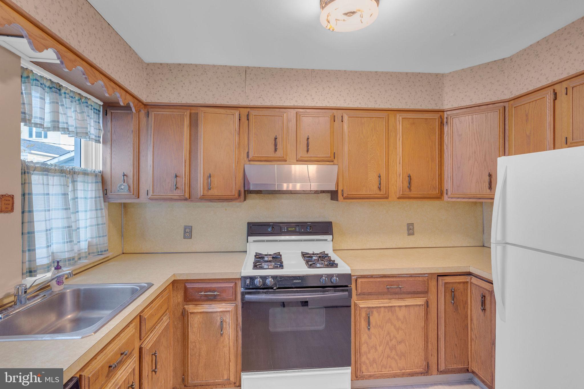 118 Hunter Avenue Hamilton, NJ 08610 - Photo 11 of 23 a kitchen with a stove a sink and a refrigerator