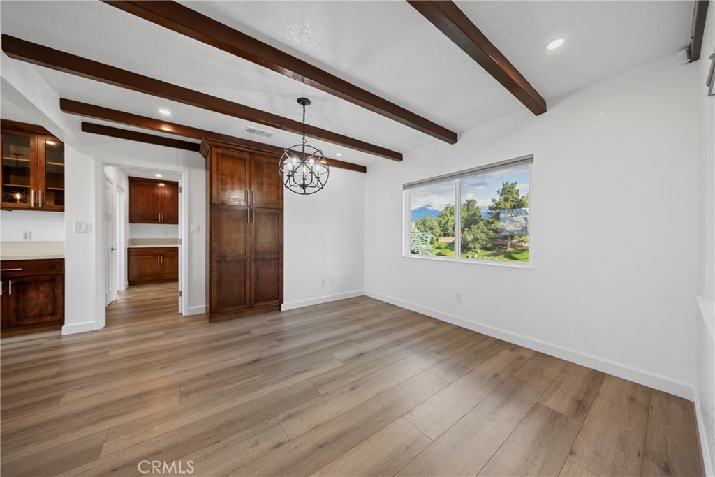 12646 10th Street Yucaipa, CA 92399 - Photo 14 of 72 an empty room with wooden floor a fireplace and windows