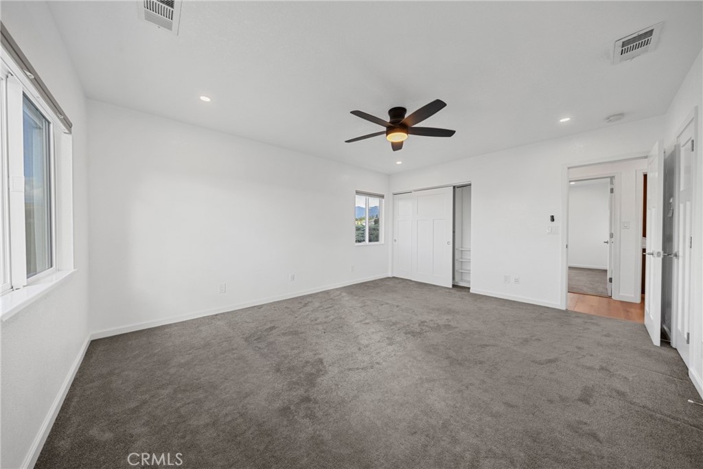 12646 10th Street Yucaipa, CA 92399 - Photo 22 of 72 an empty room with windows and a ceiling fan