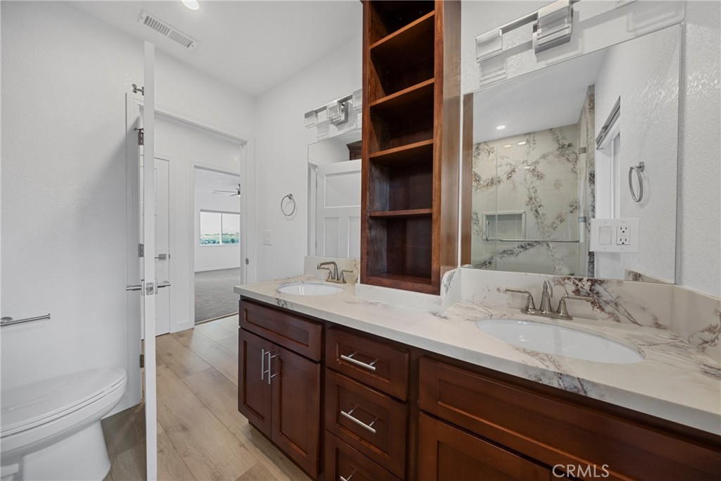 12646 10th Street Yucaipa, CA 92399 - Photo 30 of 72 a bathroom with a granite countertop sink a toilet and shower
