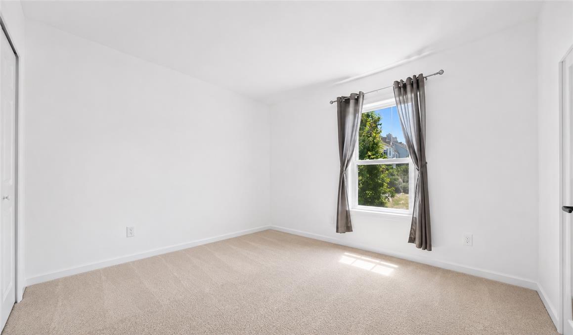 309 Hill Road Whitehall, PA 18052 - Photo 7 of 19 A well-lit bedroom features plush carpeting and a large window providing views of the neighborhood.