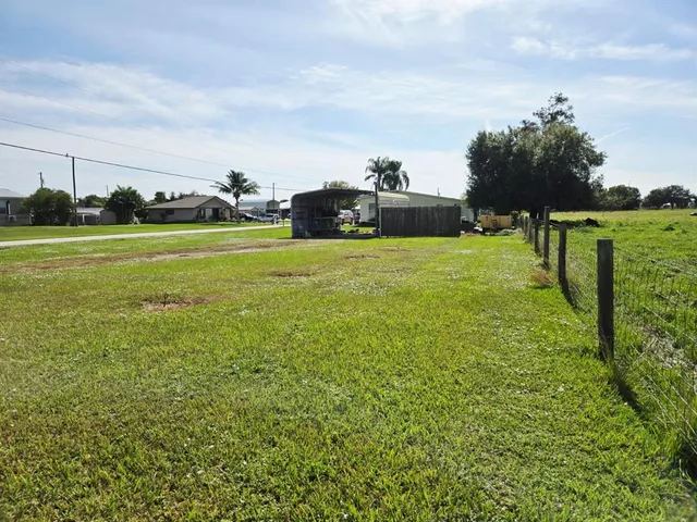 a backyard of a house with lots of green space and lake view