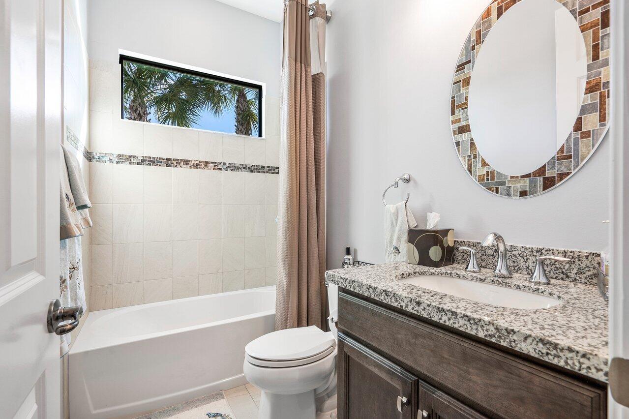 11792 Leon Circle Parkland, FL 33076 - Photo 19 of 51 a bathroom with a granite countertop sink a toilet and a mirror