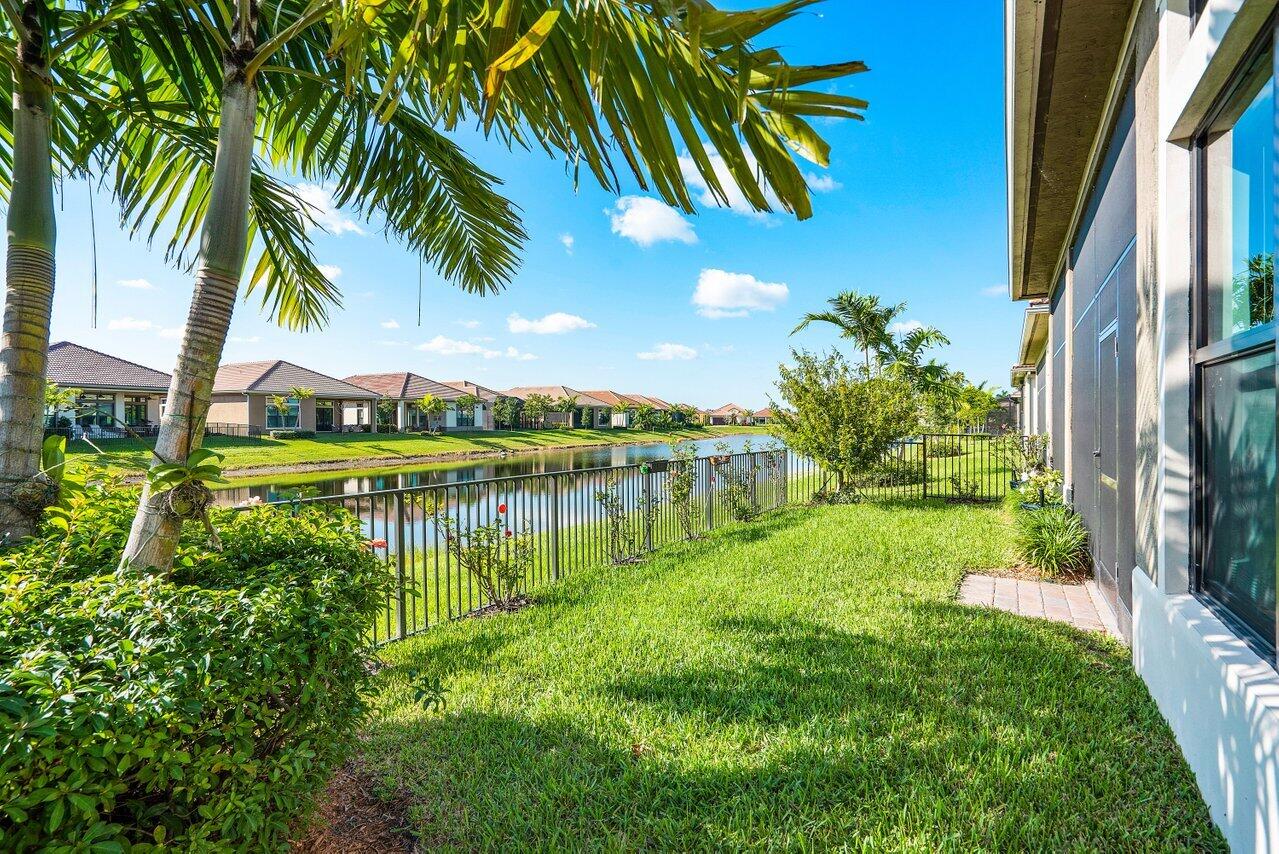 11792 Leon Circle Parkland, FL 33076 - Photo 25 of 51 a view of a lake with a big yard and palm trees