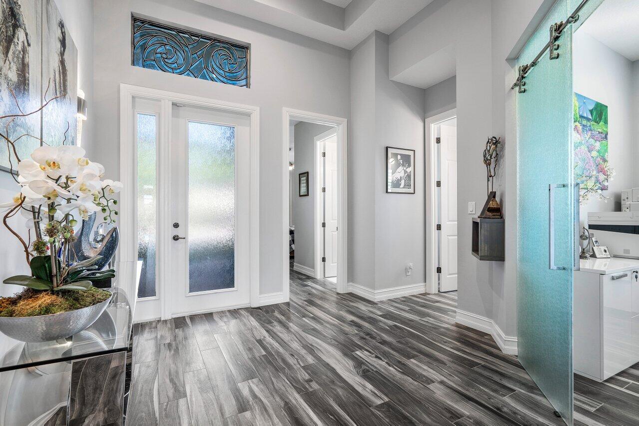 11792 Leon Circle Parkland, FL 33076 - Photo 3 of 51 a view of a hallway with wooden floor and front door