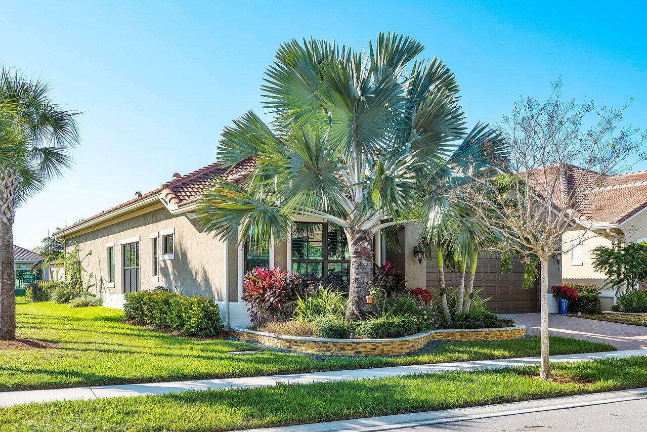 11792 Leon Circle Parkland, FL 33076 - Photo 39 of 51 a front view of a house with a garden and trees