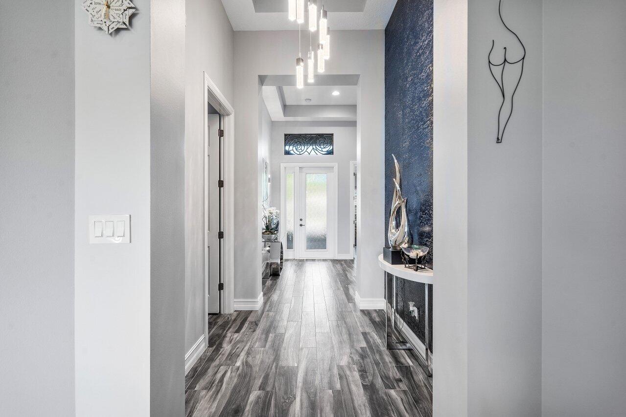 11792 Leon Circle Parkland, FL 33076 - Photo 4 of 51 a view of a hallway with wooden floor and a kitchen