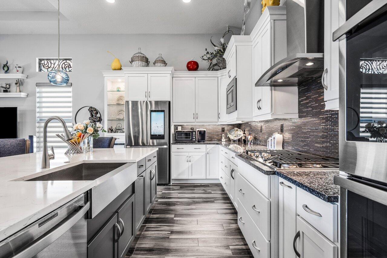11792 Leon Circle Parkland, FL 33076 - Photo 8 of 51 a kitchen with stainless steel appliances granite countertop a sink stove and cabinets