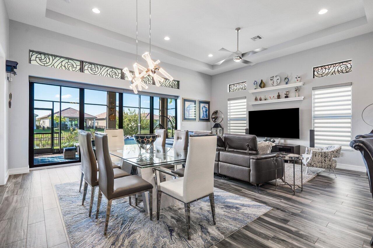 11792 Leon Circle Parkland, FL 33076 - Photo 10 of 51 a dining room with furniture a chandelier and wooden floor