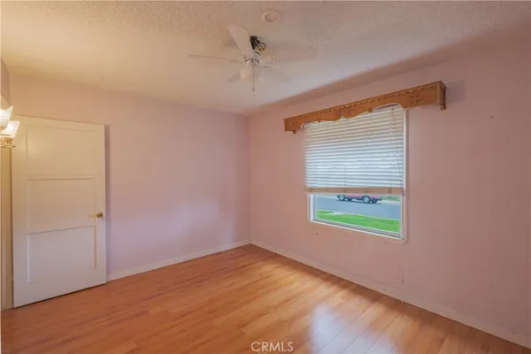 an empty room with a window and a ceiling fan