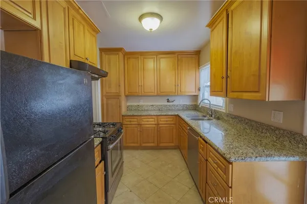 a kitchen with a sink a counter top space cabinets and appliances