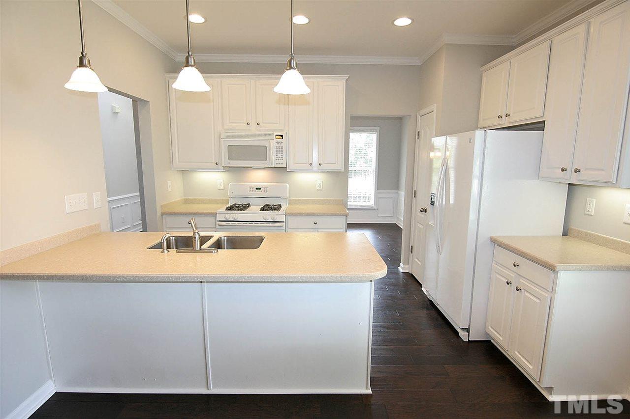 3401 Parlor Street Raleigh, NC 27614 - Photo 8 of 25 a kitchen with kitchen island granite countertop a sink cabinets and stainless steel appliances