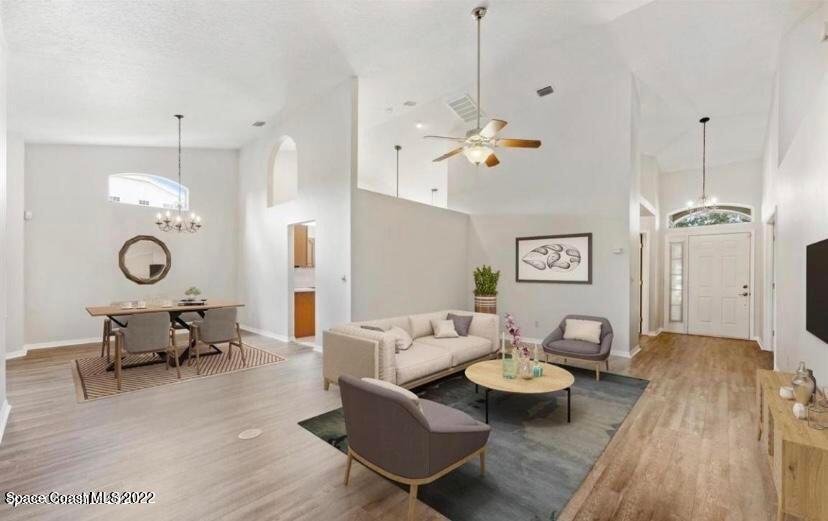 468 Prestwick Court Melbourne, FL 32940 - Photo 6 of 13 a living room with furniture kitchen view and a chandelier