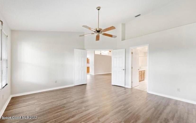 468 Prestwick Court Melbourne, FL 32940 - Photo 8 of 13 an empty room with wooden floor and ceiling fan