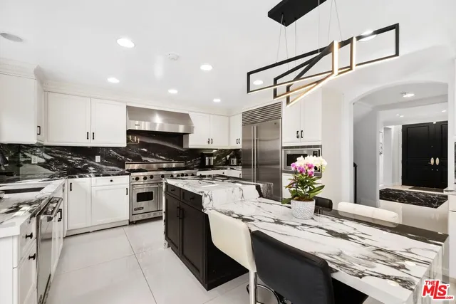 a kitchen with granite countertop a sink stainless steel appliances and cabinets