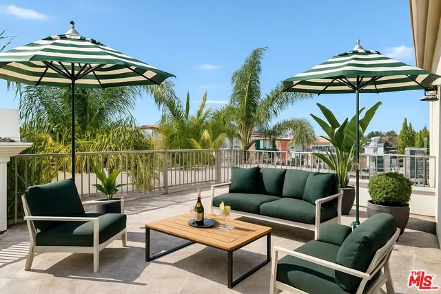 a view of a patio with couches potted plants and a table