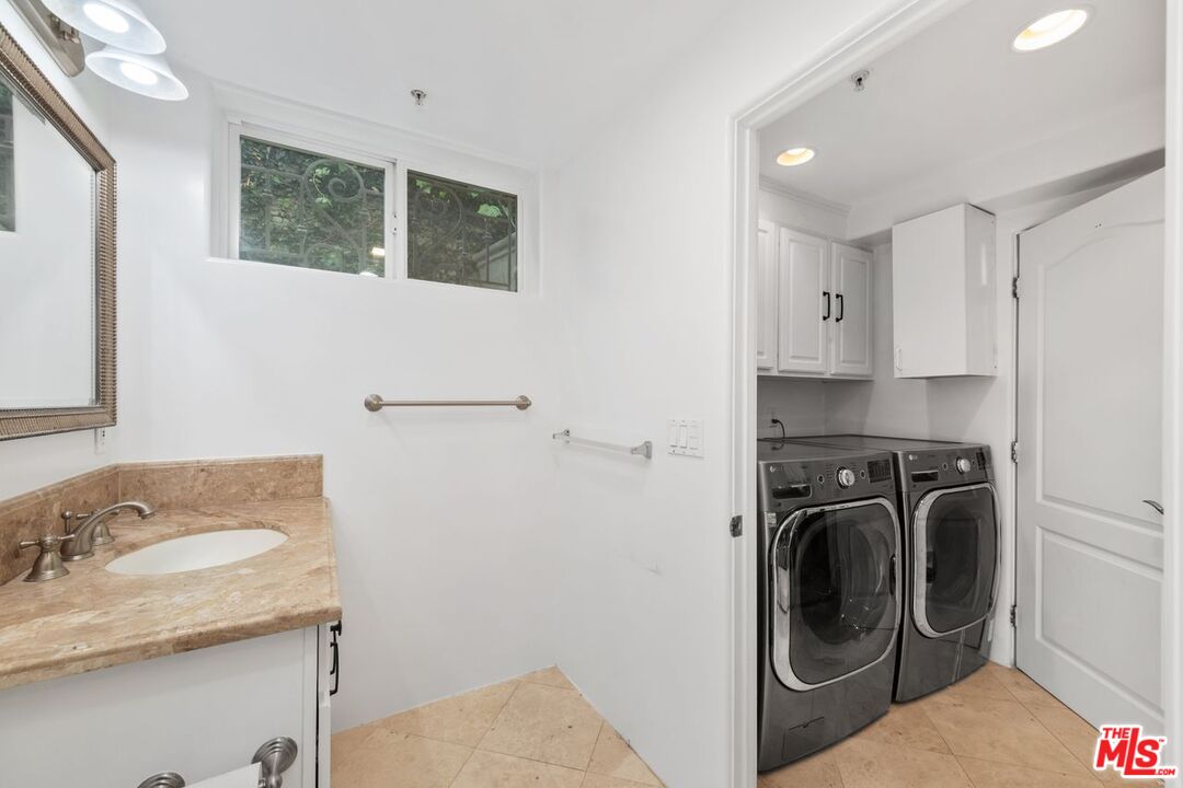11974 Mayfield Avenue, Unit 2 Los Angeles, CA 90049 - Photo 24 of 26 a bathroom with a sink a washer and dryer