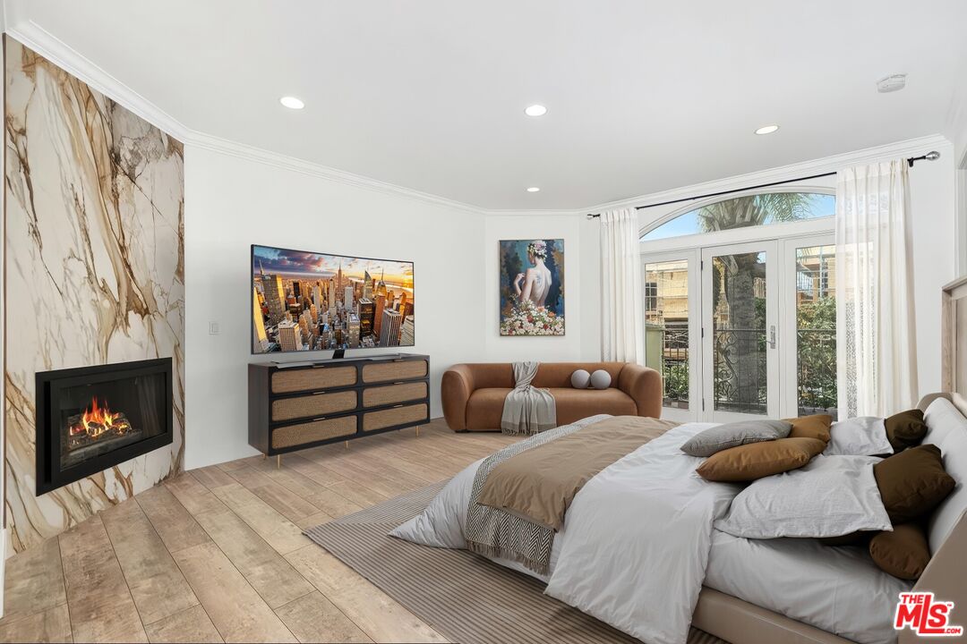 11974 Mayfield Avenue, Unit 2 Los Angeles, CA 90049 - Photo 8 of 26 a bedroom with a bed and a fireplace