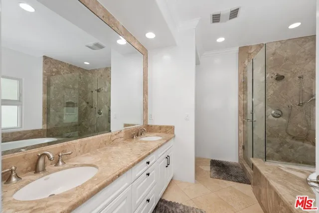 a bathroom with a granite countertop double vanity sink shower and a mirror