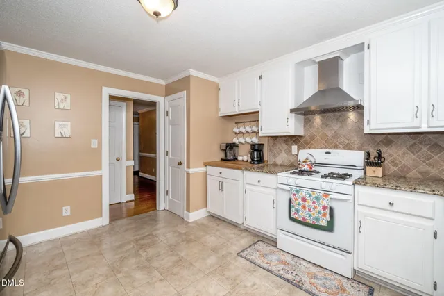 a kitchen with granite countertop white cabinets white appliances with a sink and dishwasher