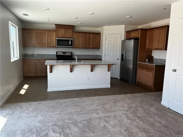 a kitchen with stainless steel appliances granite countertop a refrigerator sink and cabinets