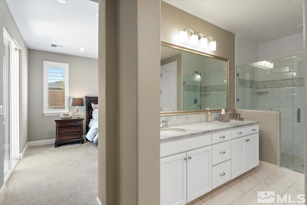 9543 Tencendur Lane Reno, NV 89521 - Photo 21 of 40 a spacious bathroom with a granite countertop sink a mirror and a