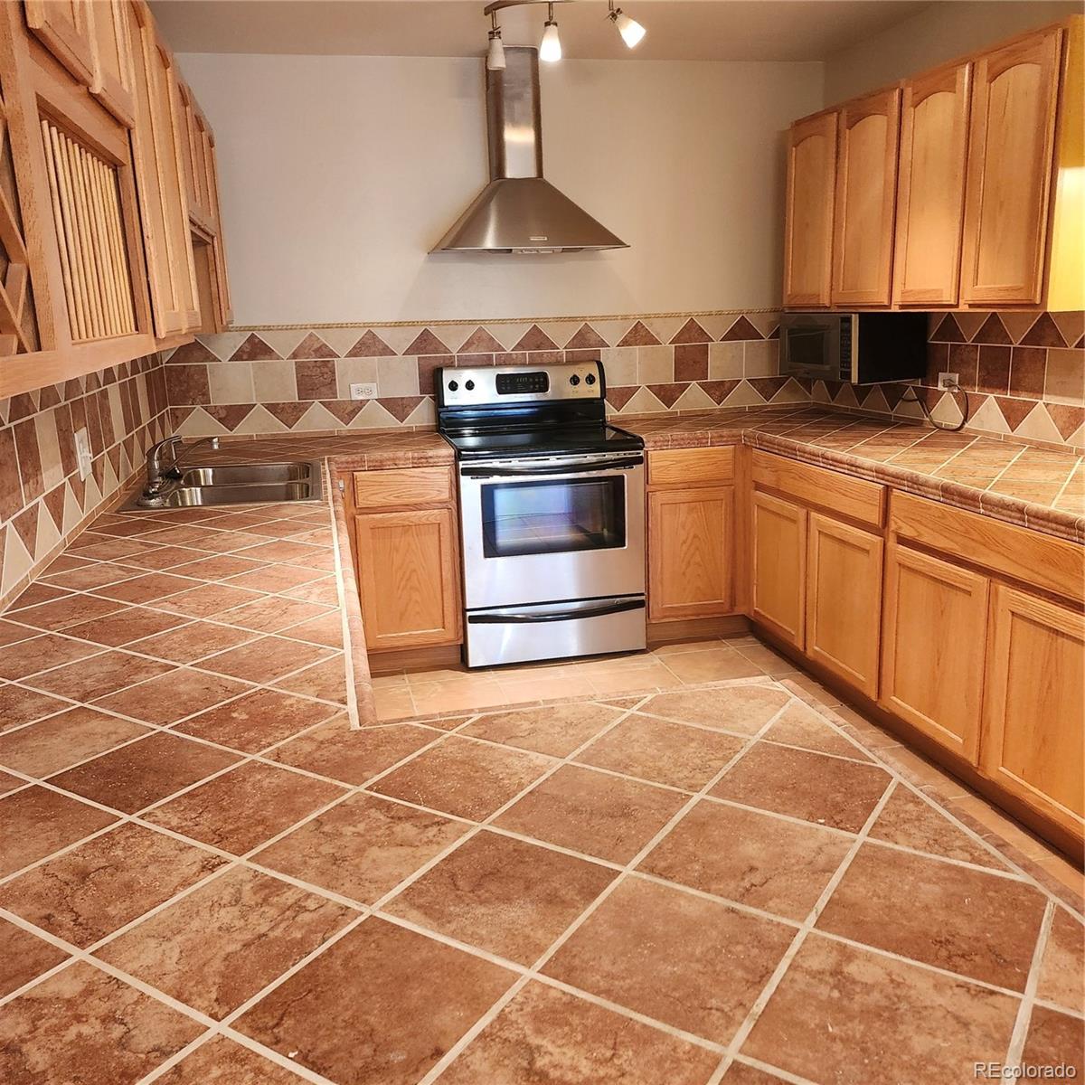 755 South Clinton Street, Unit 6B Denver, CO 80247 - Photo 14 of 48 a kitchen with a stove a sink and a cabinets