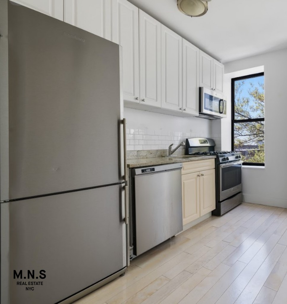 a kitchen with stainless steel appliances white cabinets and wooden floor