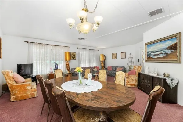 a view of a dining room with furniture and chandelier