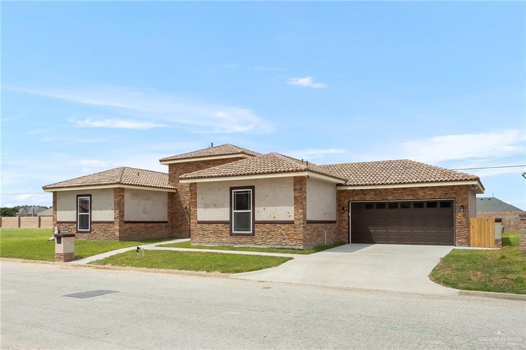1127 Fairway Lane Harlingen, TX 78552 - Photo 2 of 23 a front view of a house with a garden and garage